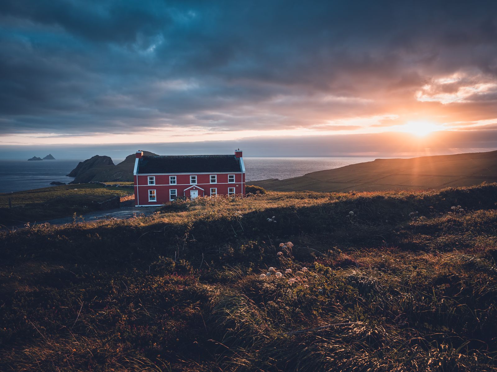 Rotes Haus an der irischen Küste bei Sonnenuntergang