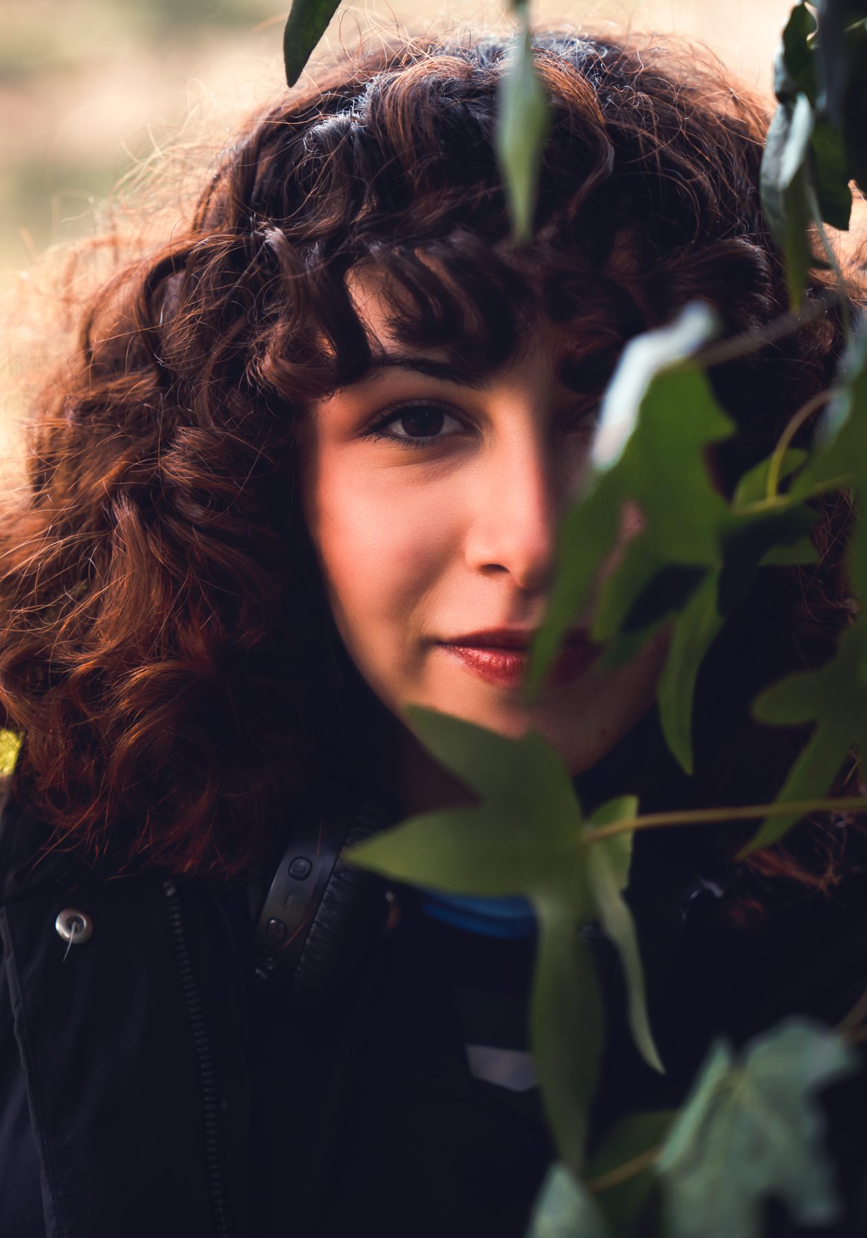 Verträumtes Portrait durch Blätter fotografiert
